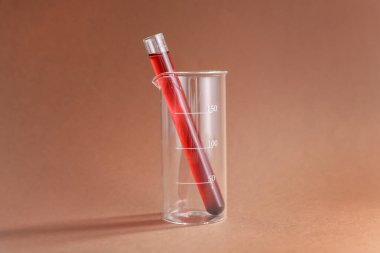 Renk arkaplanında kırmızı sıvı bulunan laboratuvar camları