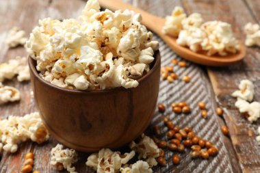 Tahta masada lezzetli patlamış mısır ve mısır taneleri, yakın plan.