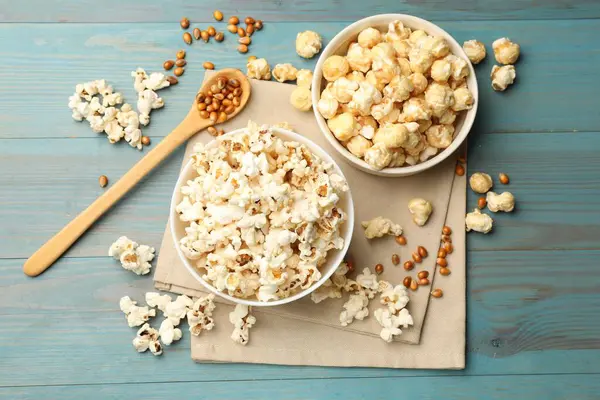 Lezzetli patlamış mısır ve mısır taneleri açık mavi ahşap masa, düz uzanmış