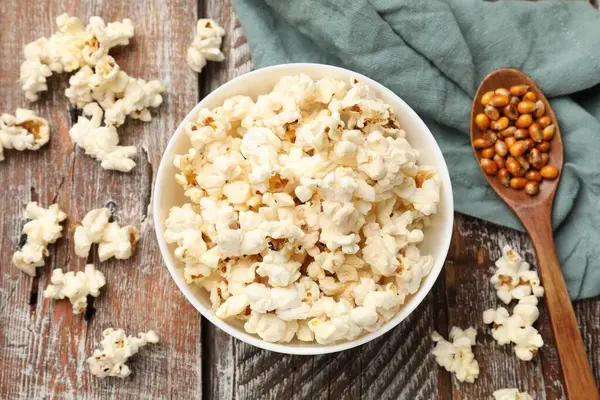 Tahta masada patlamış mısır ve mısır taneleri var.