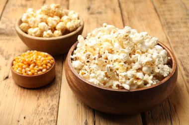 Tahta masada lezzetli patlamış mısır ve mısır taneleri, yakın plan.