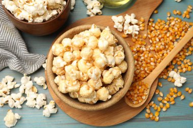 Lezzetli patlamış mısır ve mısır taneleri mavi ahşap masada, düz yerde