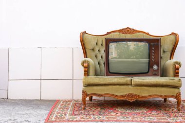 Dışarıdaki beyaz duvarın yanında kanepe ve halı üzerinde Retro TV, mesaj için yer. Kullanılmış eşyalar