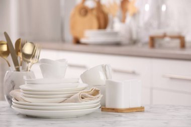 Farklı beyaz bulaşık takımları, bardaklar ve çatal bıçaklar.