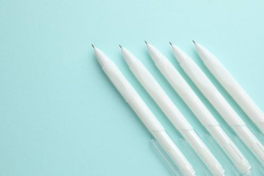 Açık mavi arka planda beyaz kalemler, düz yatıyordu. Metin için boşluk
