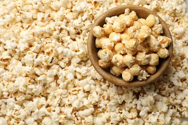 Arka plan olarak lezzetli patlamış mısır ve kase, yakın plan.