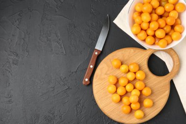 Olgun sarı kiraz erikleri, tahta tahta tahta ve siyah masa üzerinde bıçak, düz yatış. Metin için boşluk