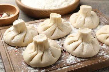 Ahşap tahtada biberli pişmemiş khinkaliler (hamur tatlısı), yakın plan.