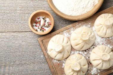 Pişmemiş khinkaliler (hamur tatlısı) ve ahşap masa üzerindeki baharatlar, düz yatak. Metin için boşluk