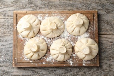 Ahşap masa üzerinde pişmemiş khinkaliler (hamur tatlısı), üst görünüm