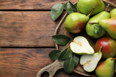 Taze armutlar ve ahşap masada yeşil yapraklar, üst manzara. Metin için boşluk