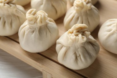 Beyaz ahşap masada pişmemiş khinkaliler (hamur tatlısı), yakın plan.