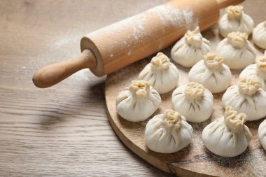 Pişmemiş khinkalis (hamur tatlısı) ve merdane ahşap masa, yakın plan