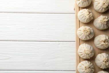 Beyaz ahşap masa üzerinde pişmemiş khinkaliler (hamur tatlısı), üst manzara. Metin için boşluk