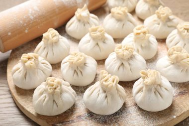 Pişmemiş khinkalis (hamur tatlısı) ve merdane ahşap masa, yakın plan