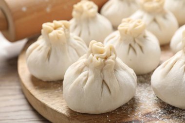 Pişmemiş khinkalis (hamur tatlısı) ve merdane ahşap masa, yakın plan