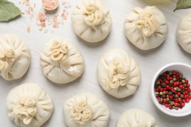 Pişmemiş khinkaliler (hamur tatlısı) ve beyaz ahşap masa üzerindeki baharatlar, düz konum