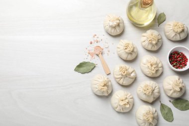 Pişmemiş khinkaliler (hamur tatlısı) ve beyaz ahşap masa üzerindeki baharatlar, düz yatış. Metin için boşluk