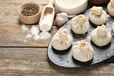 Pişmemiş khinkaliler (hamur tatlısı), un ve baharatlar ahşap masada, yakın plan. Metin için boşluk