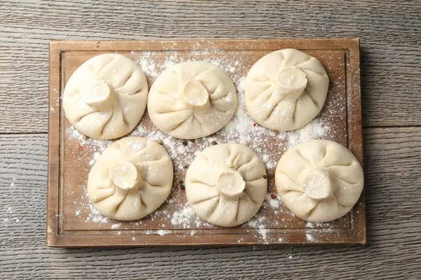 Ahşap masa üzerinde pişmemiş khinkaliler (hamur tatlısı), üst görünüm