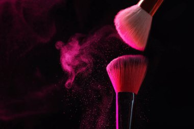Siyah arka planda pembe göz farlı makyaj fırçaları, yakın plan. Metin için boşluk