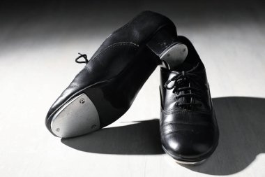 Beyaz tahta zeminde step dansı için bir çift ayakkabı, yakın plan.