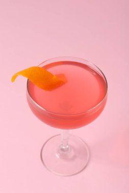 Pembe arka planda garnitürlü martini kokteyli, yakın plan.
