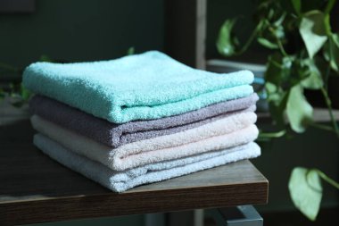 İçerideki ahşap masada temiz havlu yığını, yakın plan.