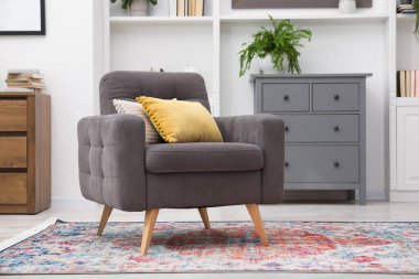 Kapalı yerde yastıklı gri koltuk. İç tasarım