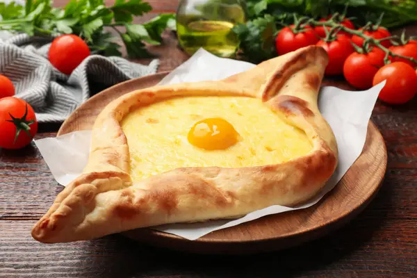 Peynirli, yumurtalı, domatesli ve maydanozlu lezzetli khachapuri.