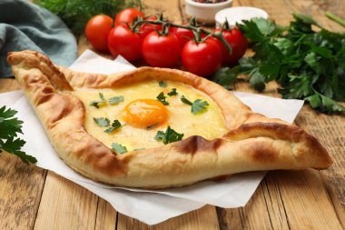 Peynirli, yumurtalı, domatesli ve maydanozlu lezzetli khachapuri.