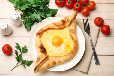 Tahta masada servis edilen peynir ve yumurtalı leziz khachapuri.