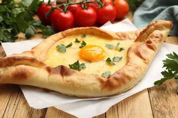 Peynirli, yumurtalı, domatesli ve maydanozlu lezzetli khachapuri.