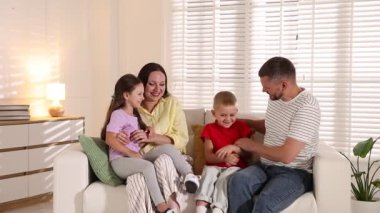 Mutlu aile evdeki kanepede eğleniyor.
