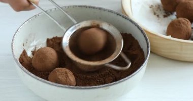 Beyaz ahşap masada ev yapımı şekerlemeler yapan kadın, yakın plan.