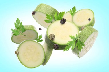 Taze kabak dilimleri, maydanoz ve turkuaz gradyan arkaplana düşen biberler.