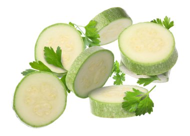 Taze kabak dilimleri ve beyaz arka plana düşen maydanoz.