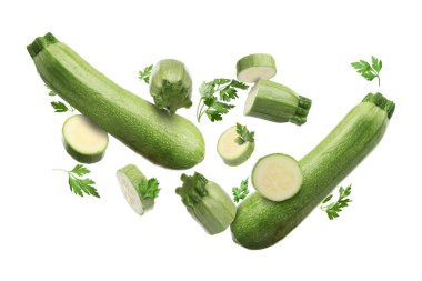 Beyaz arka plana düşen taze kabaklar ve maydanozlar.