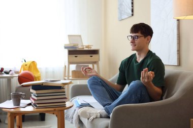 Sınava hazırlanan ve evde meditasyon yapan öğrenci.