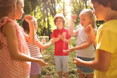 Parkta taş, kağıt ve makas oynayan sevimli çocuklar.
