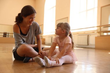 Dans sınıfında küçük bir kızla çalışırken mutlu bir bale öğretmeni.