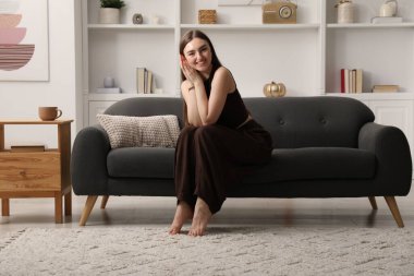 Evdeki kanepede oturan güzel kadın.