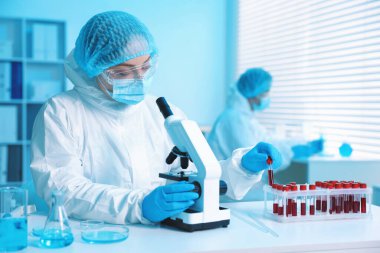 Tıbbi analiz. Laboratuvarda mikroskopla çalışan bilim adamı, seçici odaklanma