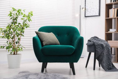 Kapalı yerde yastıklı şık bir koltuk. İç tasarım