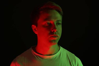 Siyah arka plana karşı neon ışıklı yakışıklı bir adam.