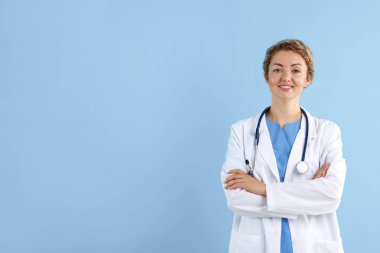 Açık mavi arka planda steteskobu olan profesyonel bir çocuk doktoru portresi. Metin için boşluk