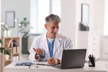 Teletıp. Doktor, bilgisayarla hastayla içeride görüntülü konuşma yapıyor.