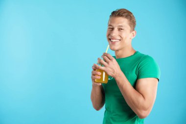 Meyve suyu ve açık mavi arka planda saman içen adam, metin için boşluk