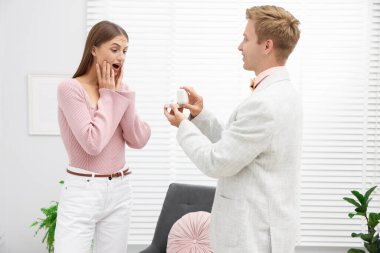 Nişan yüzüklü bir adam evde sürpriz kız arkadaşına evlenme teklif ediyor.