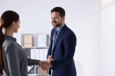 İş ortakları ofiste tokalaşıyor, mesaj için yer var.